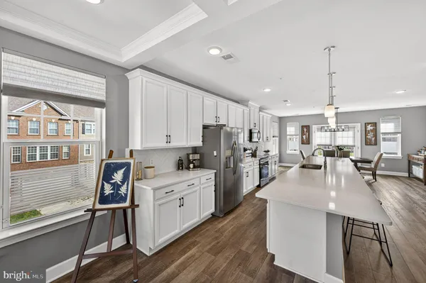 a kitchen with stainless steel appliances granite countertop a lot of counter space and wooden floors