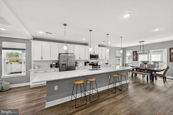 a large kitchen with kitchen island a stove a sink a dining table and chairs