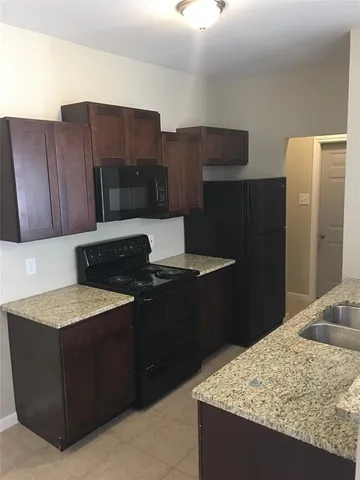 a kitchen with a sink refrigerator and cabinets