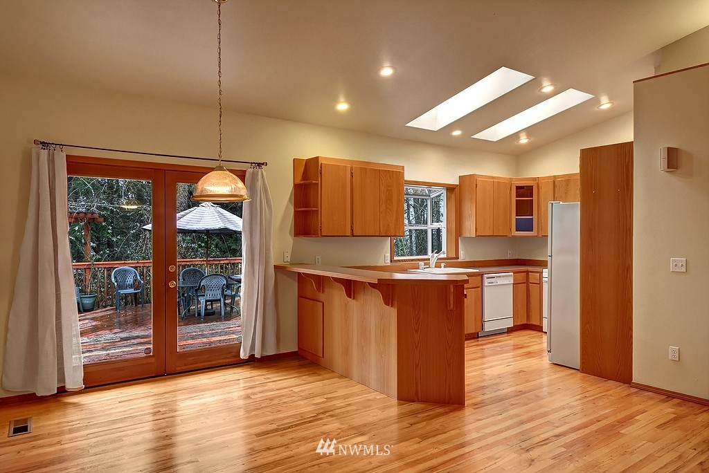 20223 Southeast 152nd Street Renton, WA 98059 - Photo 6 of 18 a kitchen with stainless steel appliances kitchen island granite countertop a refrigerator a stove and a wooden floors
