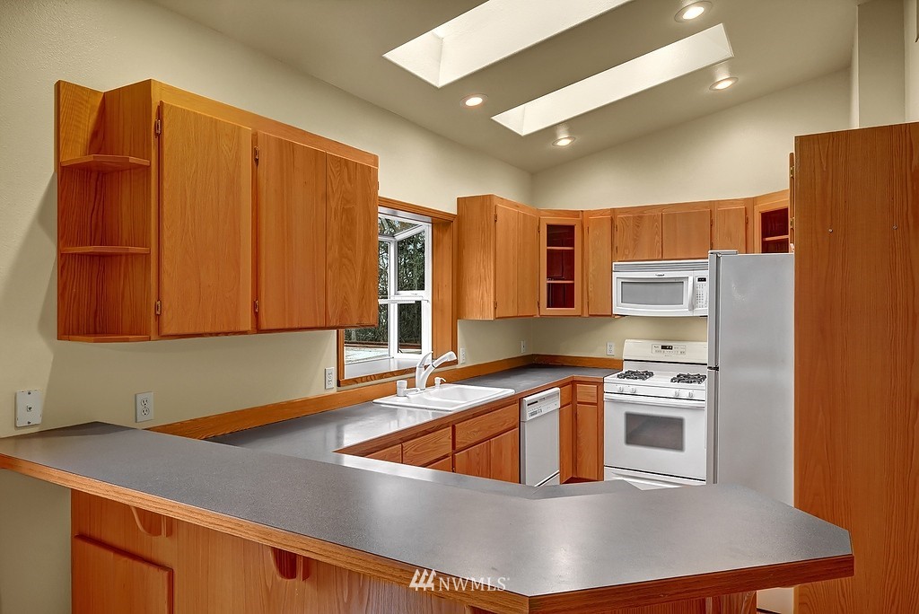 20223 Southeast 152nd Street Renton, WA 98059 - Photo 7 of 18 a kitchen with stainless steel appliances granite countertop a sink a stove and a refrigerator