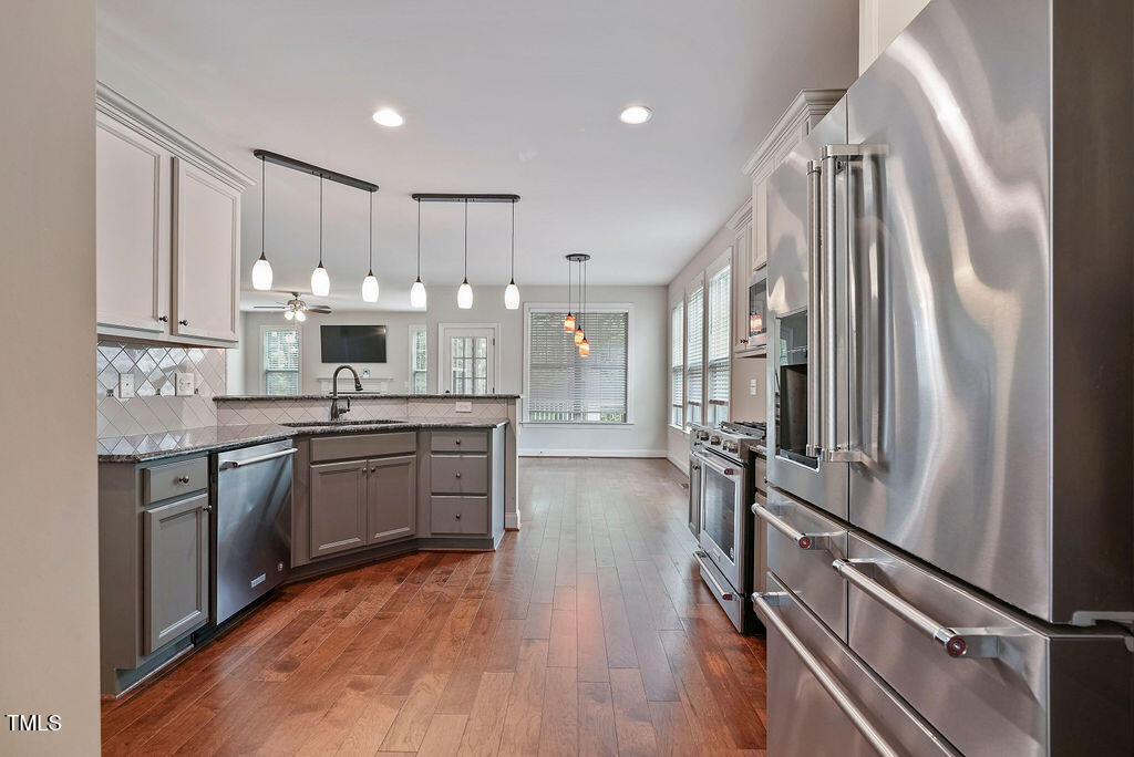 1124 Armsleigh Court Raleigh, NC 27603 - Photo 14 of 33 a kitchen with kitchen island granite countertop a stove refrigerator and cabinets