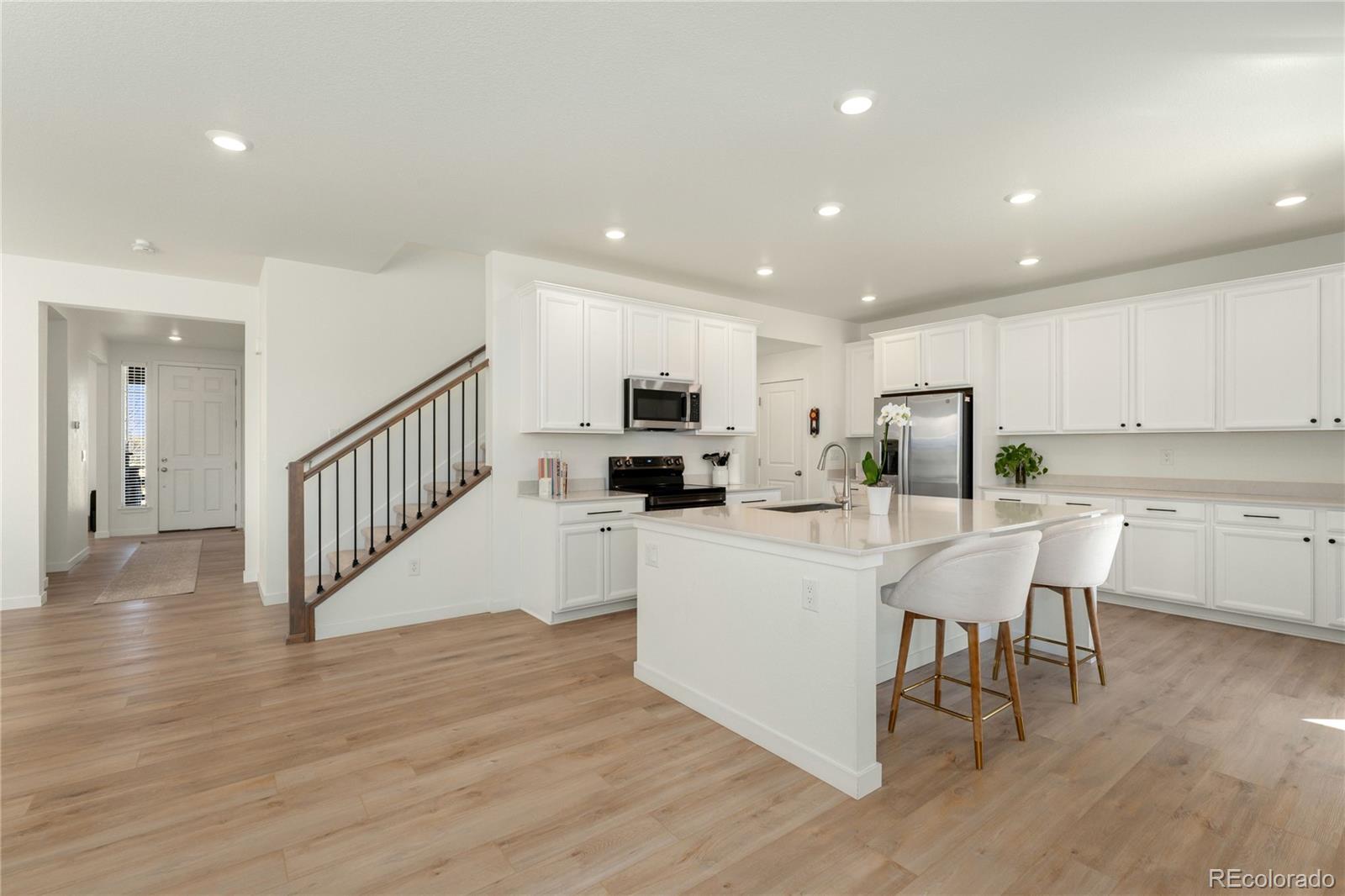 817 S Flat Aurora, CO 80018 - Photo 13 of 41 a large white kitchen with wooden floor and a sink