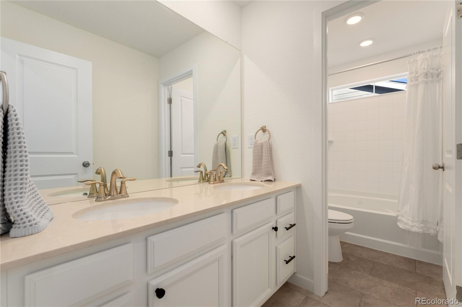 817 S Flat Aurora, CO 80018 - Photo 25 of 41 a bathroom with a double vanity sink toilet and a mirror