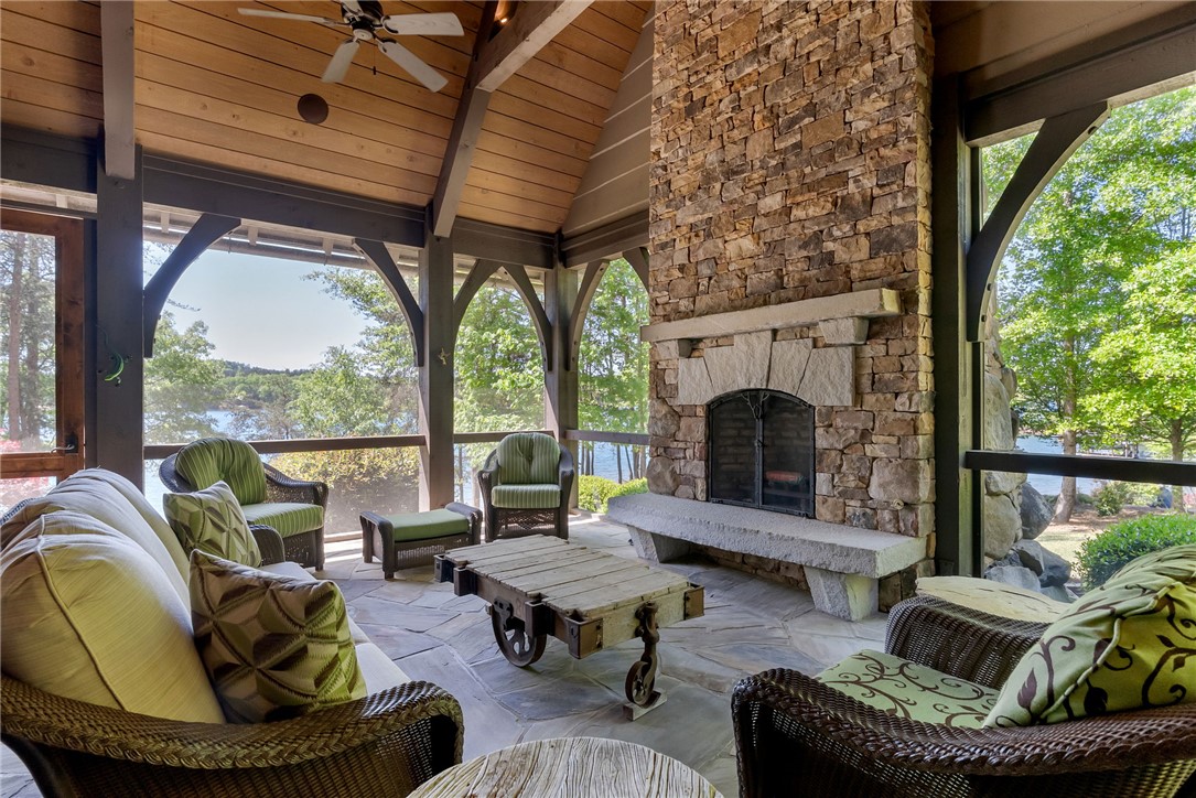 104 Crooked Stick Court Sunset, SC 29685 - Photo 14 of 43 This inviting porch offers tranquil lake views and a cozy fireplace, perfect for outdoor relaxation.