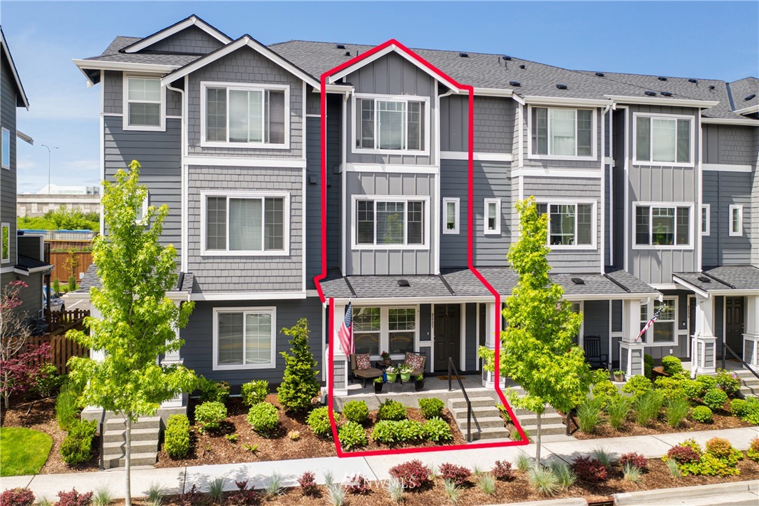 a view of a brick house with windows and flower plants