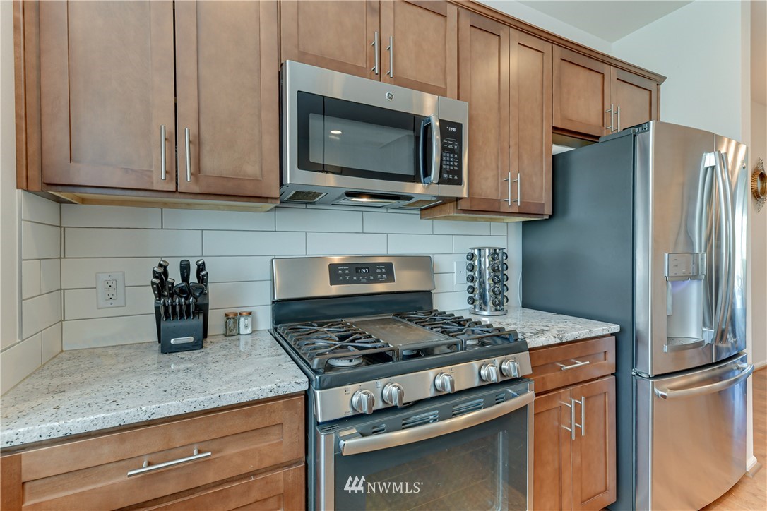 3337 30th Drive Everett, WA 98201 - Photo 18 of 28 a kitchen with stainless steel appliances granite countertop a stove microwave refrigerator and sink