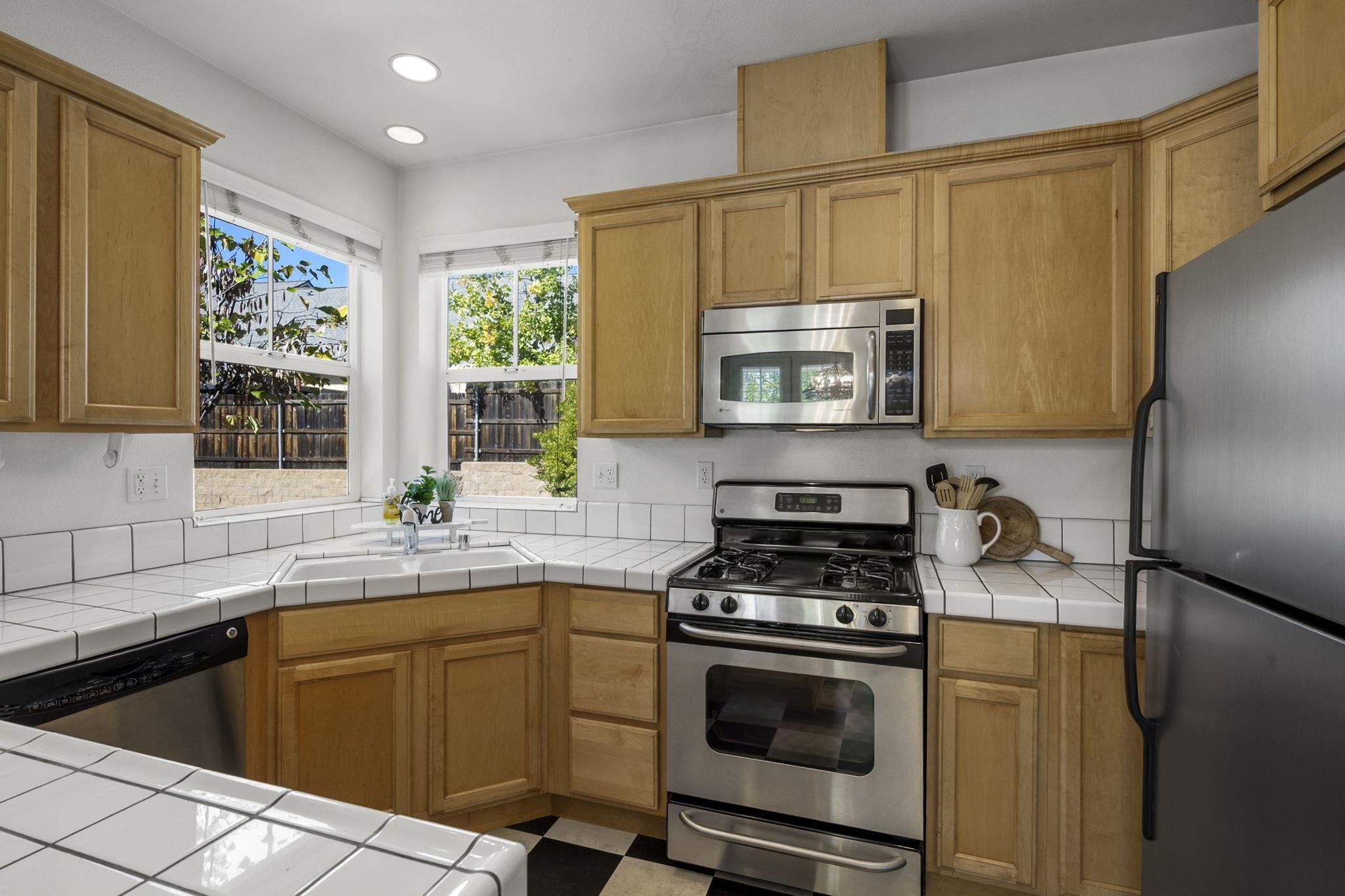 343 Field Stone Drive Murphys, CA 95247 - Photo 15 of 40 Kitchen with appliances with stainless steel finishes, tile countertops, recessed lighting, and brown cabinetry
