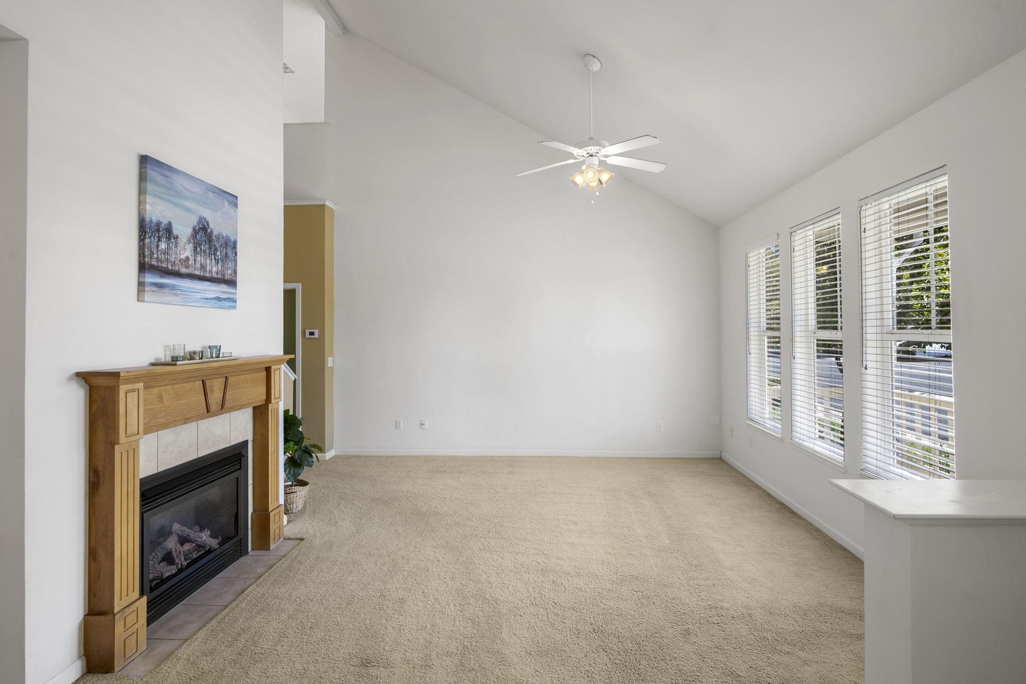 343 Field Stone Drive Murphys, CA 95247 - Photo 9 of 40 Unfurnished living room featuring a fireplace, light carpet, a ceiling fan, and high vaulted ceiling
