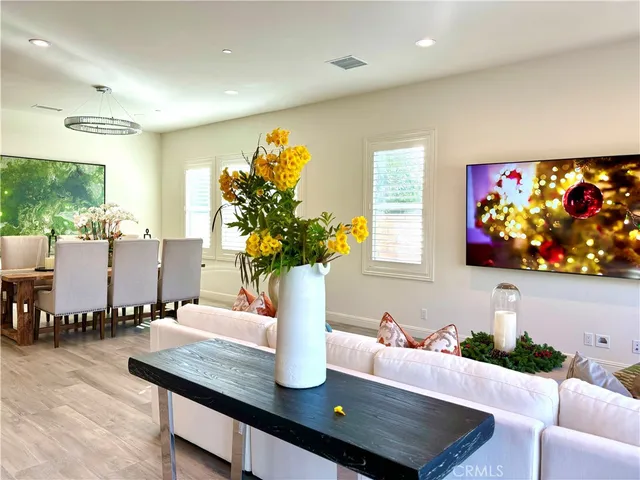 a view of a dining room with furniture a potted plant and wooden floor