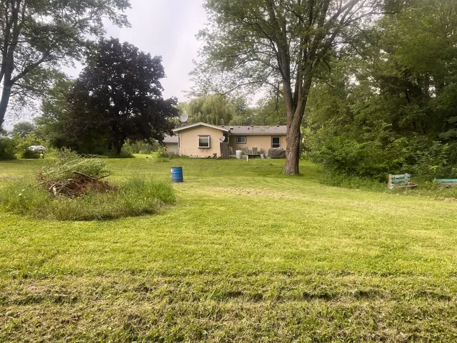 a view of a garden with a house and large trees