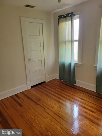 an empty room with wooden floor and closet