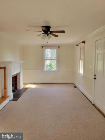 an empty room with windows and fireplace