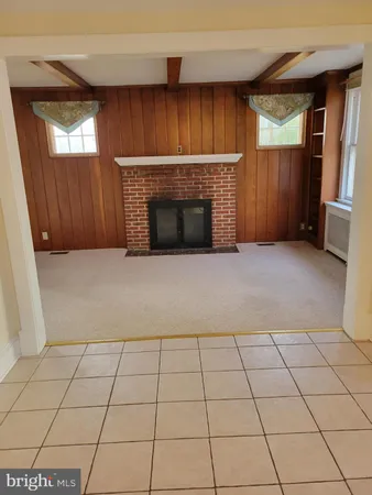a view of an empty room with a fireplace and a window