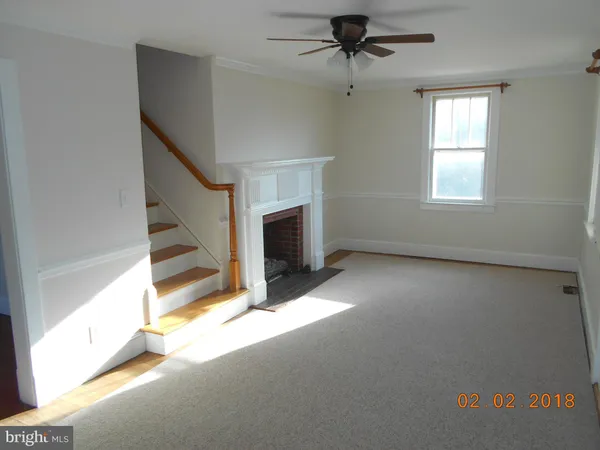 a view of an empty room with a fireplace and a window