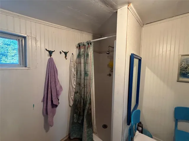 a bathroom with a shower and a glass door