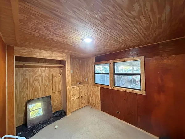 a view of an empty room with a fireplace and a window