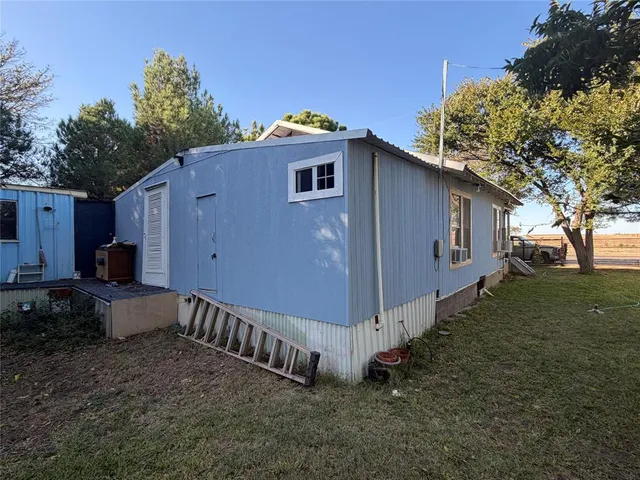 a view of a house with backyard and trees