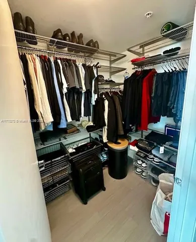 a view of walk in closet with clothes and shoes