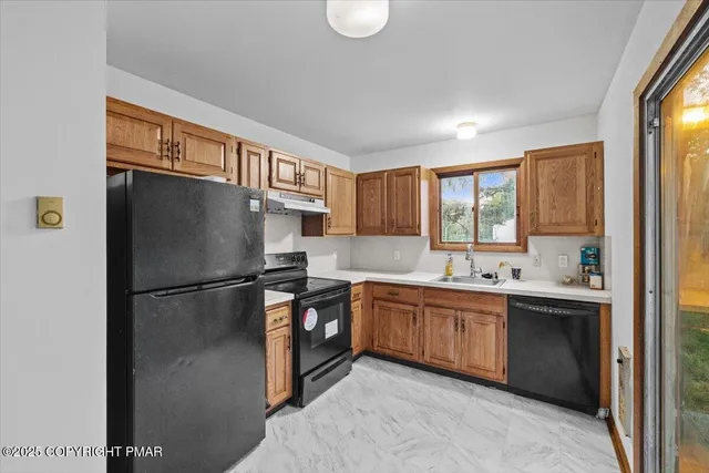 a kitchen with stainless steel appliances granite countertop a refrigerator a sink a stove and a refrigerator