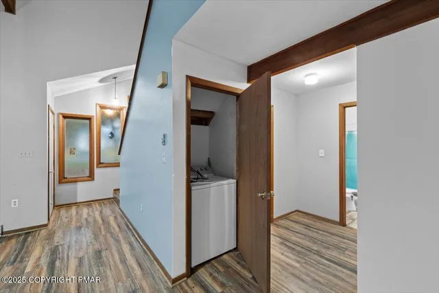 a view of a hallway with wooden floor and staircase