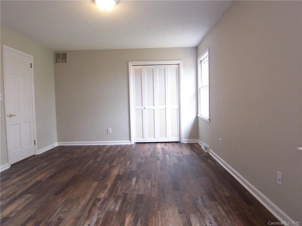 3804 Fallston Road Shelby, NC 28150 - Photo 11 of 24 a view of an empty room with wooden floor and a window