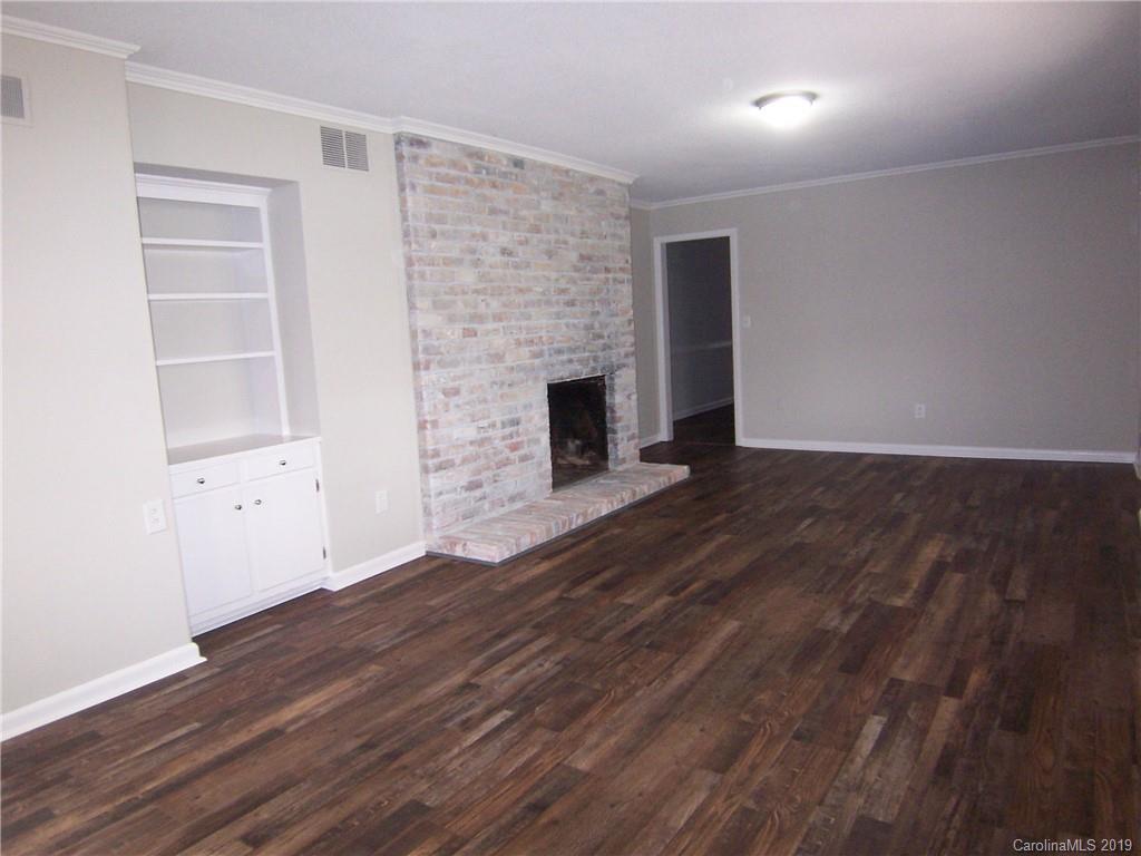 3804 Fallston Road Shelby, NC 28150 - Photo 7 of 24 an empty room with wooden floor and fireplace