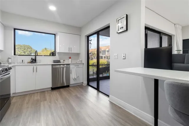 a kitchen with a sink a refrigerator and cabinets