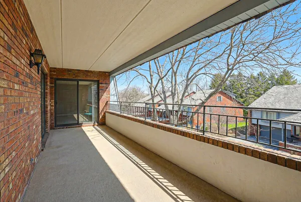 a view of a balcony with a large window and wooden floor