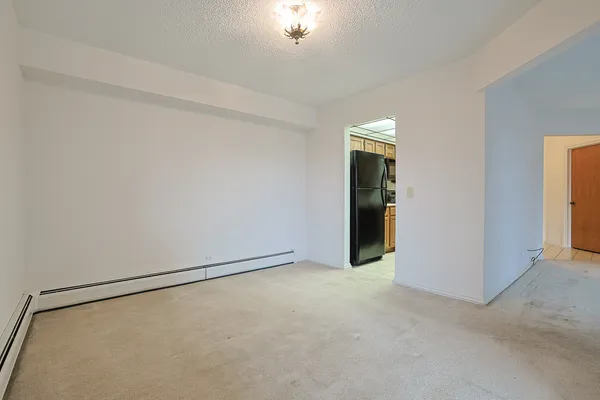 a view of an empty room with closet and a window