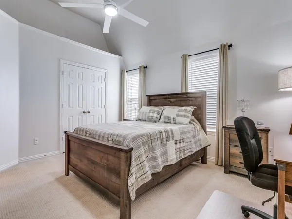 a bedroom with a bed chair and windows