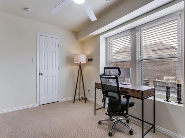 a view of a workspace with furniture and a window