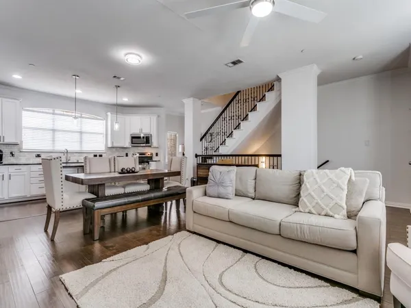 a living room with stainless steel appliances furniture and a kitchen view