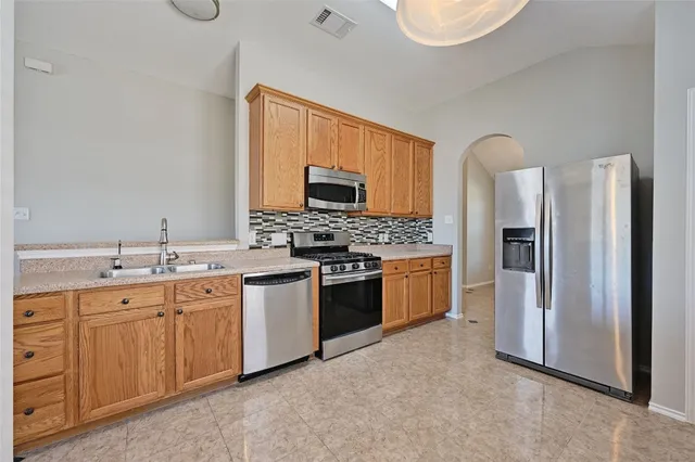 a kitchen with stainless steel appliances a refrigerator stove and sink