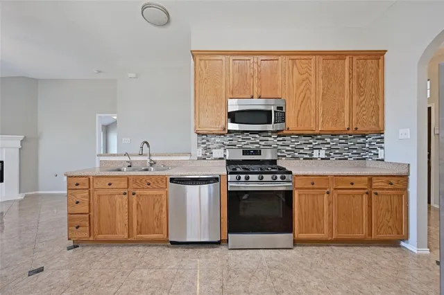 a kitchen with stainless steel appliances a stove sink and microwave
