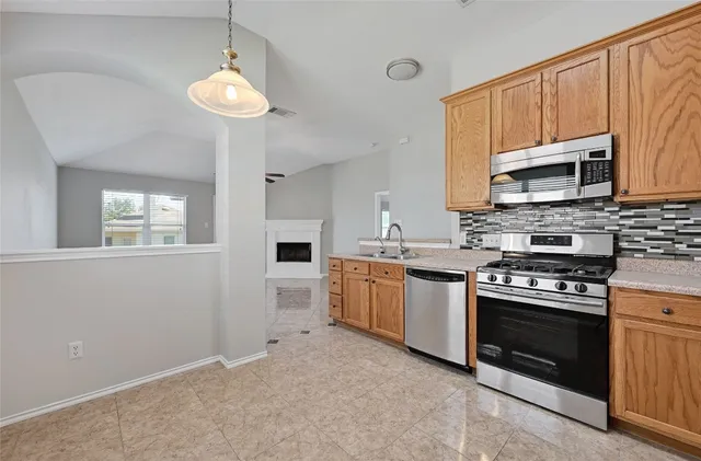a kitchen with granite countertop a stove top oven microwave and cabinets