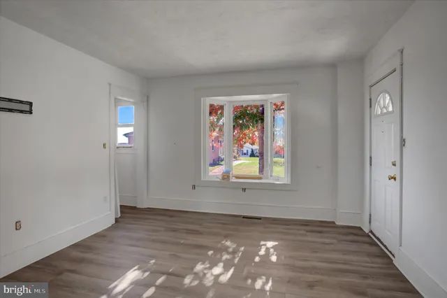 an empty room with window and wooden floor