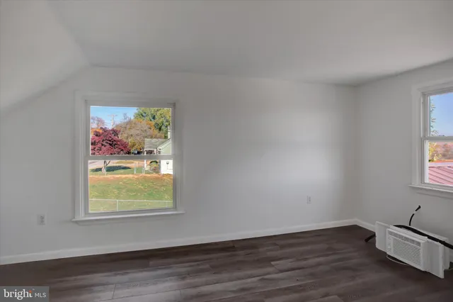 an empty room with wooden floor and window