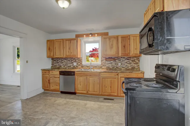 a kitchen with granite countertop a sink stainless steel appliances and cabinets