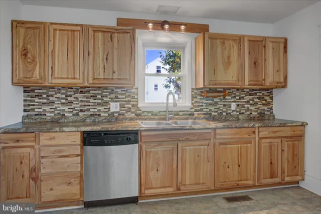 a kitchen with stainless steel appliances granite countertop a sink and cabinets