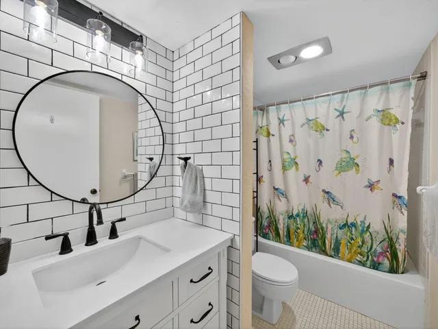 a bathroom with a sink a toilet and shower curtain