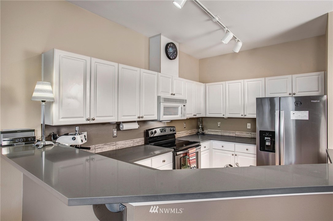17426 Bothell Way Northeast, Unit A402 Bothell, WA 98011 - Photo 13 of 29 a kitchen with stainless steel appliances granite countertop a sink a stove and refrigerator