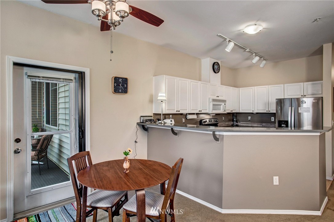 17426 Bothell Way Northeast, Unit A402 Bothell, WA 98011 - Photo 18 of 29 a kitchen with a dining table chairs and refrigerator