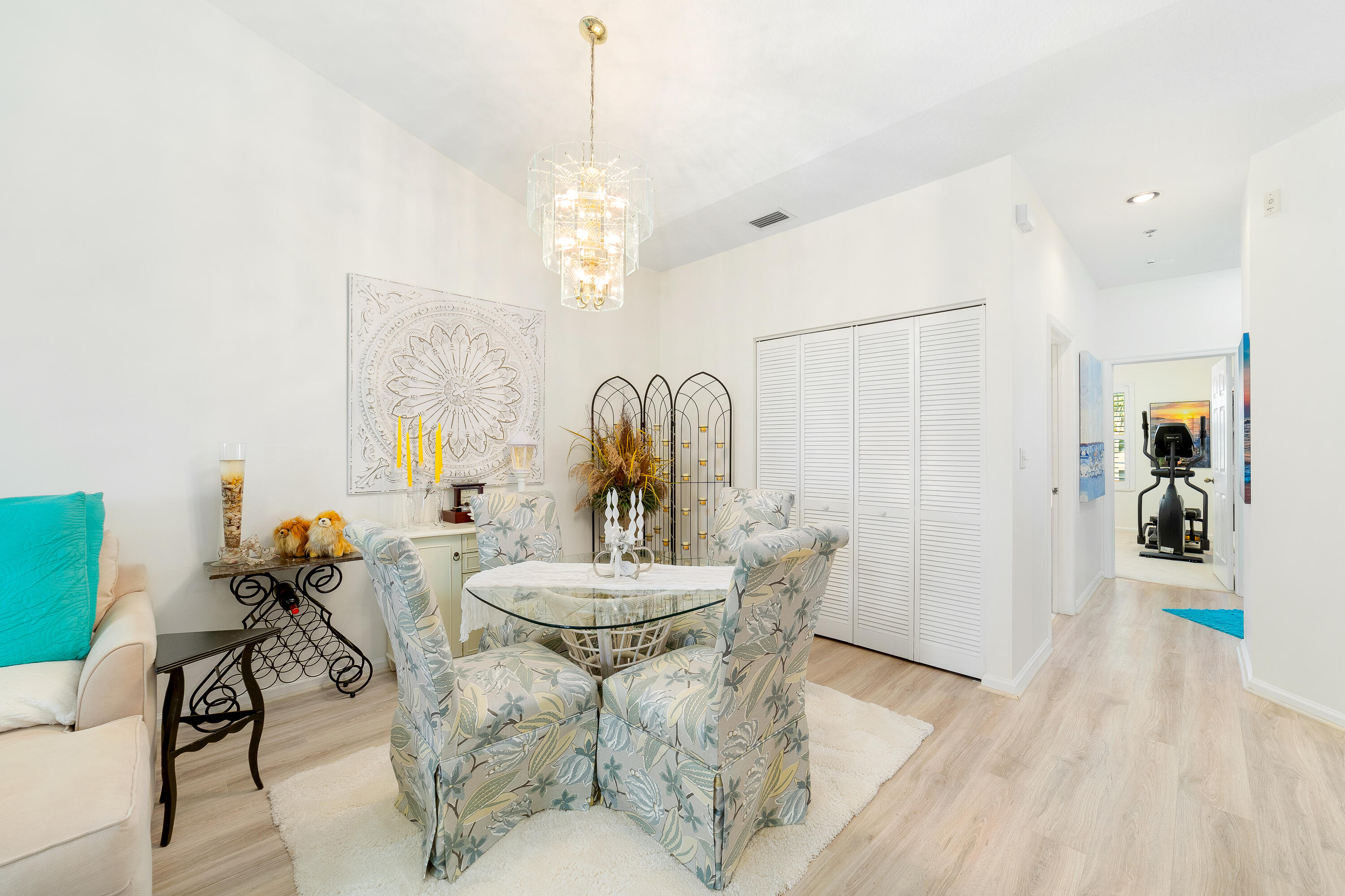 6121 Southeast Landing Way, Unit 12 Stuart, FL 34997 - Photo 20 of 47 a living room with furniture a chandelier and a dining table