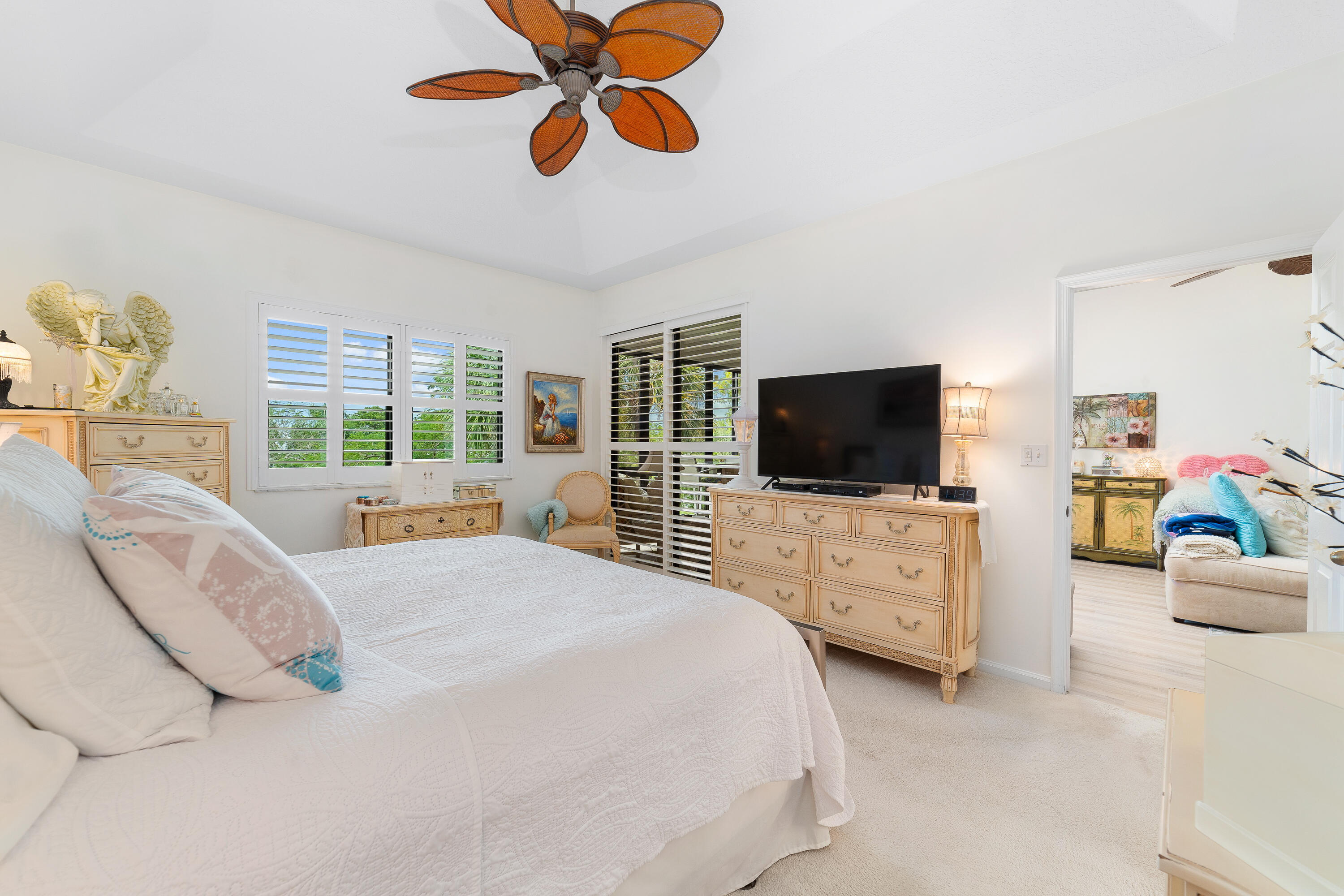 6121 Southeast Landing Way, Unit 12 Stuart, FL 34997 - Photo 22 of 47 a bedroom with a bed a dresser and a flat screen tv