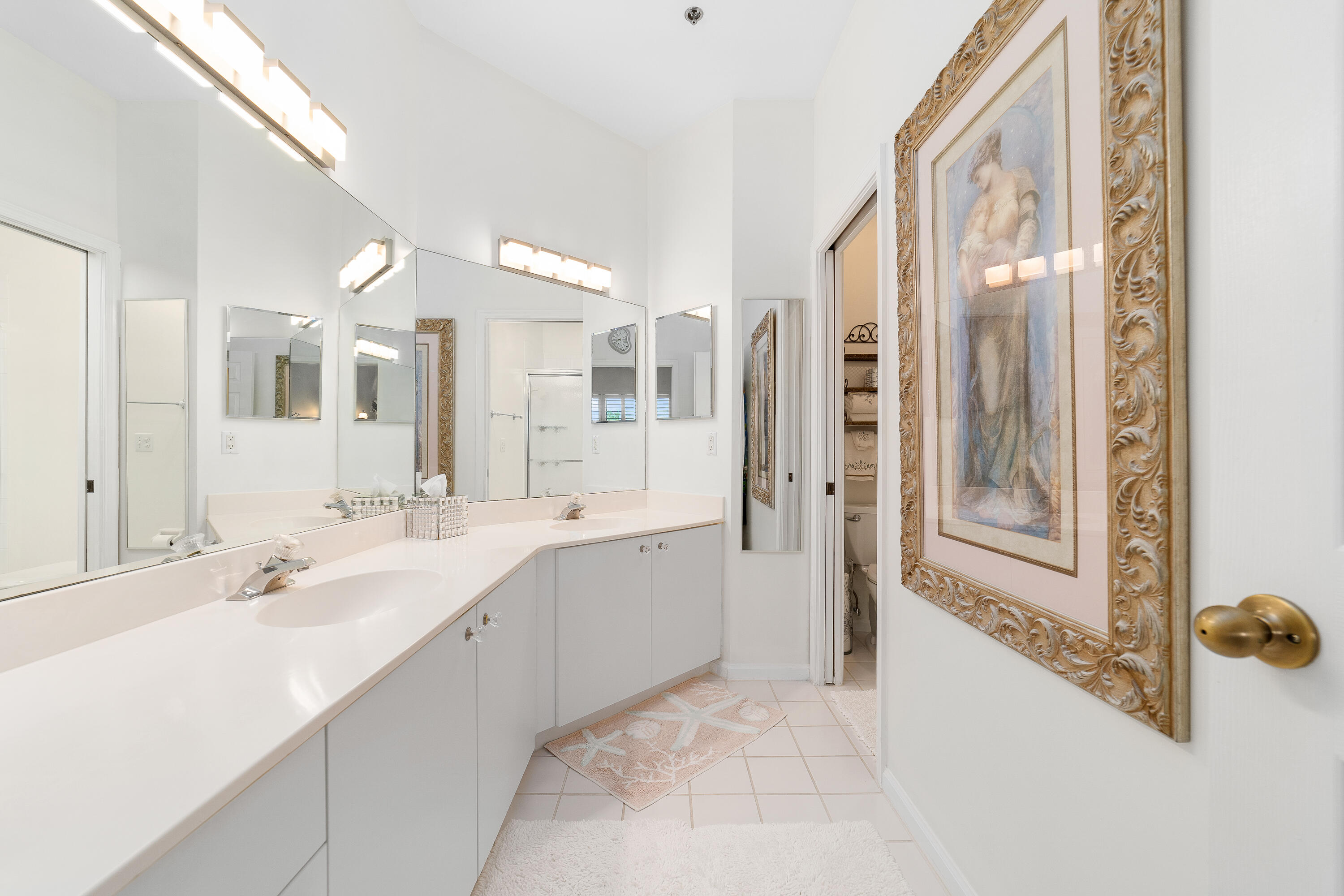 6121 Southeast Landing Way, Unit 12 Stuart, FL 34997 - Photo 23 of 47 a large bathroom with a double vanity sink and mirror with shower