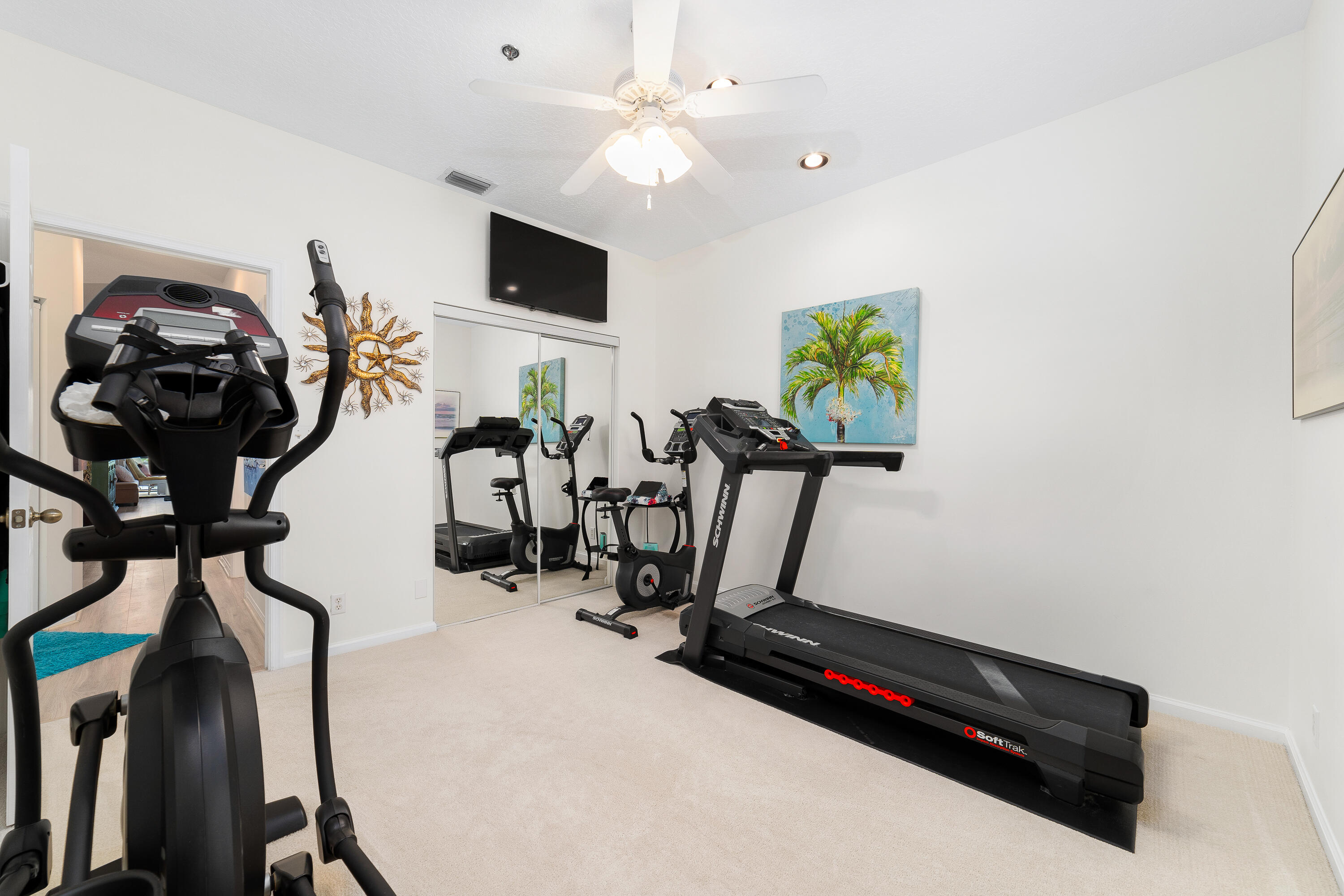 6121 Southeast Landing Way, Unit 12 Stuart, FL 34997 - Photo 30 of 47 a room with gym equipment and a flat screen tv