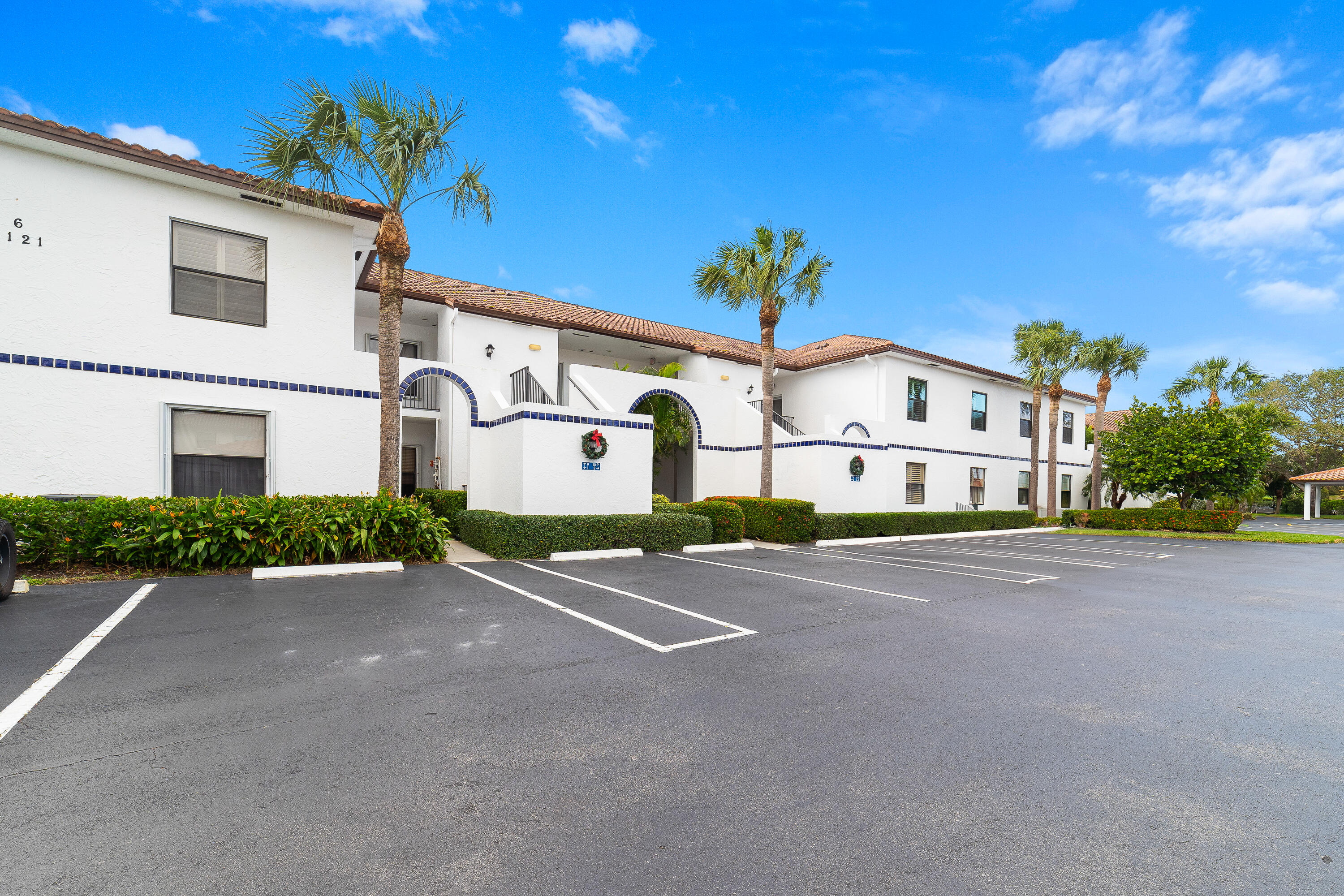 6121 Southeast Landing Way, Unit 12 Stuart, FL 34997 - Photo 32 of 47 a front view of a house with a yard and garage