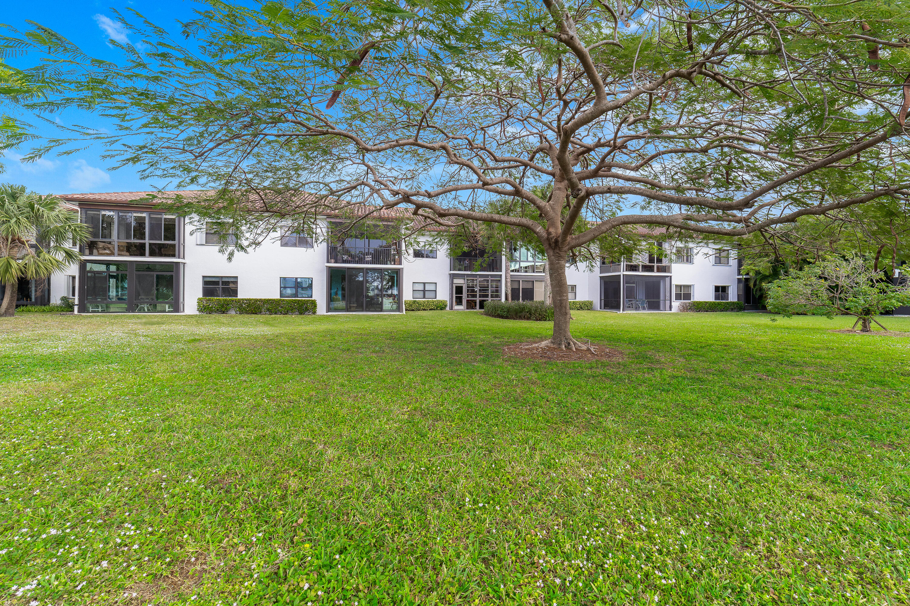 6121 Southeast Landing Way, Unit 12 Stuart, FL 34997 - Photo 33 of 47 a view of a house with a big yard and large trees