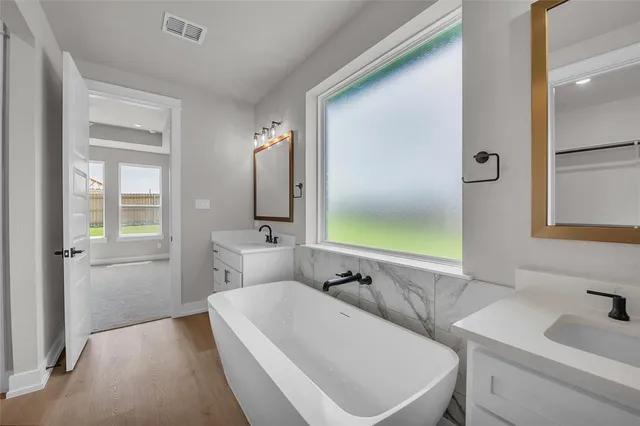 a bathroom with a sink a mirror a bathtub and shower